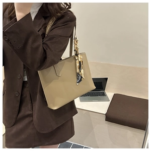 Detail of khaki tote bag with patterned silk scarf handle and matte leather finish