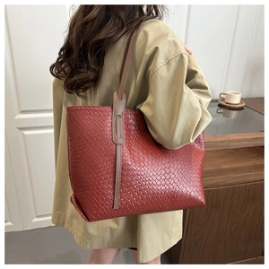 Detail of red woven texture on a large tote bag with brown leather shoulder straps