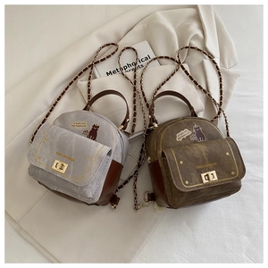Détail de mini sacs en toile et cuir avec illustration de chat et bandoulière en chaîne