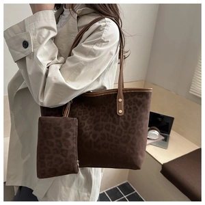 Close-up of leopard print tote bag with gold stud hardware and matching small pouch