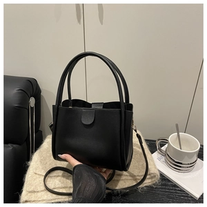 Detail showing the matte black PU leather bucket bag with top handle and shoulder strap