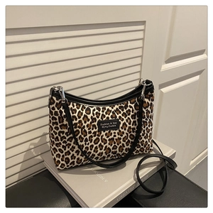Detail of leopard print tote bag with black faux leather trim and brand label