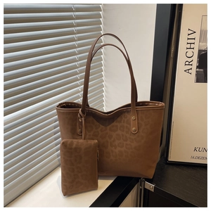 Detail of trendy leopard print tote bag set featuring soft suede texture and gold rivets
