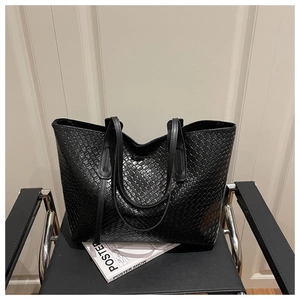Detail of black woven texture large tote bag on chair with modern design aesthetic