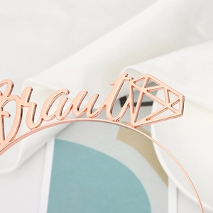 Detail of rose gold bridal headband featuring BRAUT lettering and diamond motif
