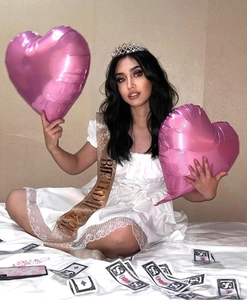 Detail of glitter birthday queen sash and rhinestone tiara set on a white lace dress