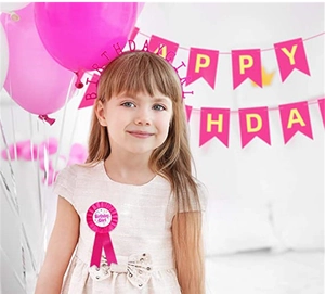 Close-up of pink Birthday Girl headband and badge accessory set for party celebration