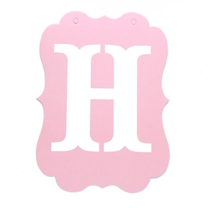 Close-up of pink banner card with white letter H and two hanging holes for birthday party