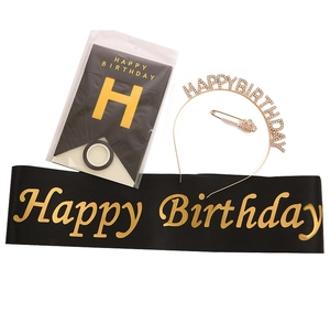Detail of happy birthday party set including black gold sash, tiara, banner, and crown brooch