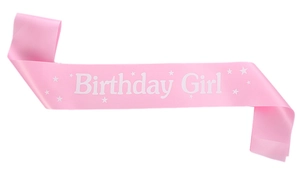 Detailed view of pink satin Birthday Girl sash with white lettering and star patterns