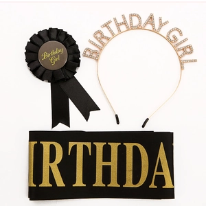 Close-up of birthday girl set including golden rhinestone headband and black satin badge