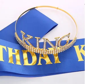 Macro detail of gold King crown with rhinestones and navy Birthday King sash set