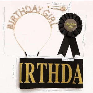 Close-up of birthday girl party set including gold tiara, black sash and satin badge