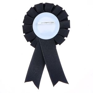 Back view of black birthday girl rosette badge with metal pin on white background