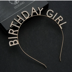 Detail of golden Birthday Girl headband with white rhinestones on black background