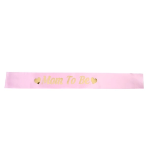 Détail de l'écharpe en satin rose Mom To Be avec lettrage doré pour baby shower