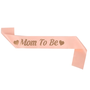 Détail de l'écharpe de baby shower avec texte doré Mom To Be sur ruban en satin rose