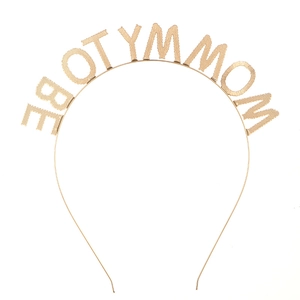 Dettaglio del cerchietto in metallo dorato con scritta Mommy To Be per baby shower