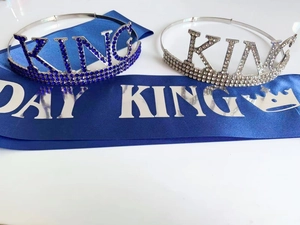 Close-up of sparkling Birthday King tiara crowns and elegant navy blue satin party sash