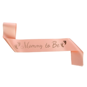 Pink satin Mommy to Be sash with gold lettering and footprints for baby shower party