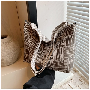 Detail of striped canvas tote bag with geometric patterns and wide jacquard strap