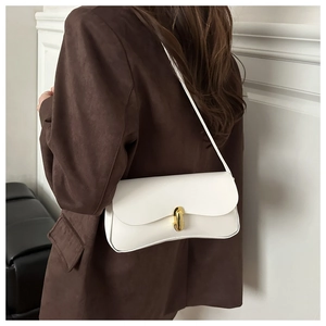 Detail of white minimalist leather underarm bag with gold metal buckle on model