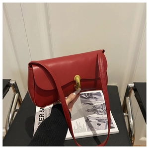Close-up of red PU leather underarm bag with gold metal buckle and smooth texture