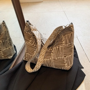 Brown and beige geometric woven canvas tote bag with textured stripes and wide shoulder strap