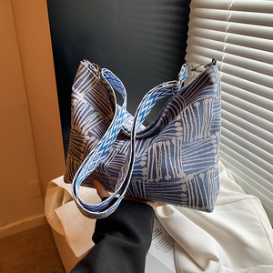 Blue and beige woven tote bag with a wide geometric strap for autumn casual style