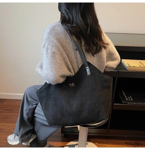 Détails d'un sac cabas noir matelassé en daim avec fermoir métallique rotatif classique