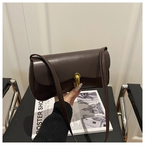 Close-up of a brown underarm bag featuring a vintage golden twist lock and sleek PU leather