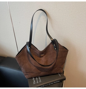 Détail d'un sac cabas matelassé marron en daim avec un fermoir rotatif en métal doré chic
