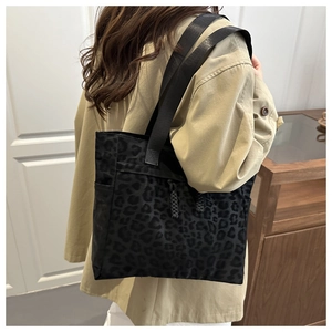 Detail of shadow leopard print tote bag with wide strap and side pocket on a model