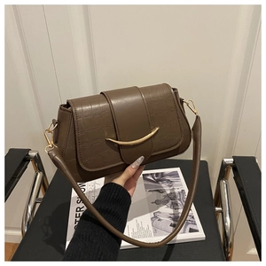 Detail of the brown crocodile texture and gold metal buckle on this vintage shoulder bag