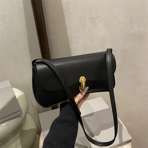Chic black faux leather baguette bag with a premium golden rotating metal buckle clasp
