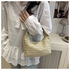 Détail du sac bandoulière en paille beige avec tissage texturé en V sur un design demi-lune