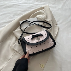 Pink and black bow shoulder bag with heart pendant in a stylish crossbody design
