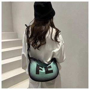 Détail du sac bandoulière dégradé vert menthe avec impression de lettres FE noires