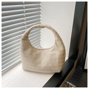 Détail de la texture tissée naturelle et de l'anse de ce sac à bandoulière en paille beige