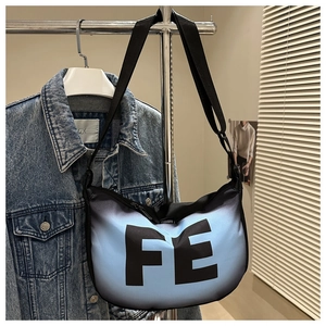 Detail of blue and black gradient canvas bag with bold FE letter print and adjustable strap