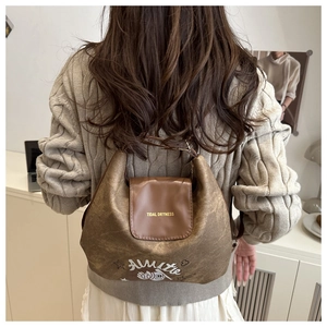 Detail of vintage brown tote bag with leather flap featuring printed Tidal Dryness text