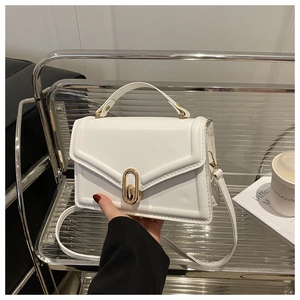 Detail of white PU leather crossbody bag with V-shaped envelope flap and gold buckle