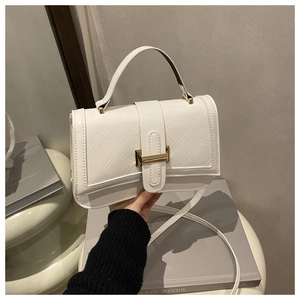 Detail of white quilted crossbody bag featuring a golden lock and elegant embroidery