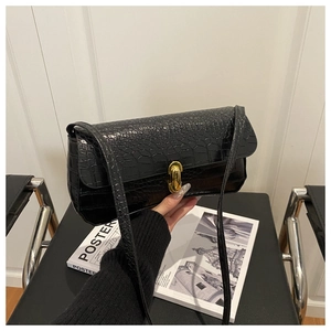 Vue détaillée de la texture cuir crocodile noir et de la boucle en métal doré chic