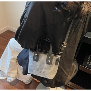 Model wearing a grey and black vintage patchwork tote bag in a minimalist room