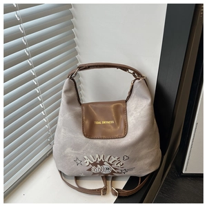 Detail of grey canvas tote bag with brown leather flap and stylish graphic print
