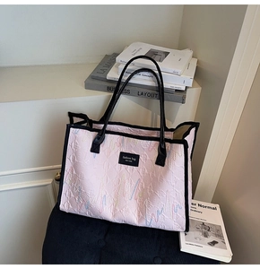 Close-up of pink tote bag with wave embroidery, sequins and fashion bag brand tag