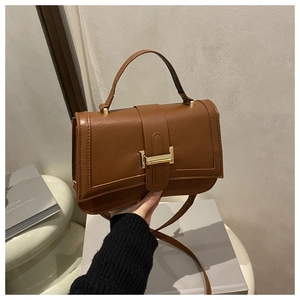 Detailed view of the brown vintage crossbody bag with golden metal clasp and top handle
