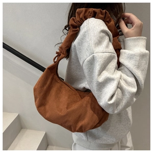 Détail du sac hobo en daim marron caramel avec bandoulière à volants plissés rétro