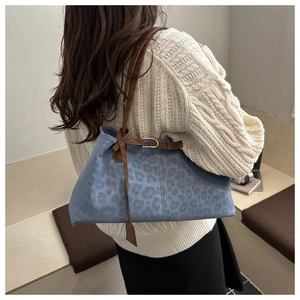 Détail du sac à bandoulière bleu à motif léopard en daim doux avec fine sangle brune